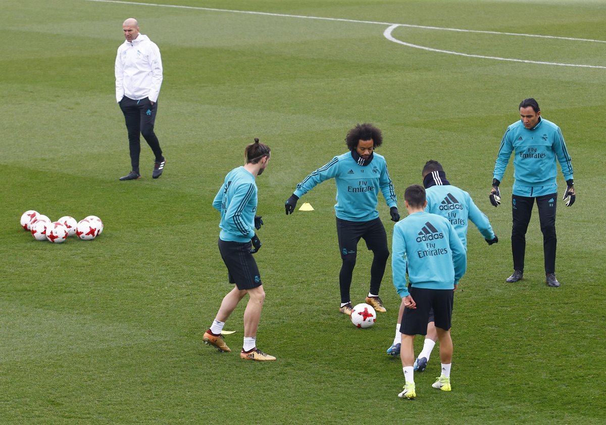 Los jugadores del Real Madrid, Gareth Bale, Marcelo, Keylor Navas realizaron ejercicios con el balón mientras son observados por el entrenador Zinedine Zidane. (Foto Prensa Libre: EFE)