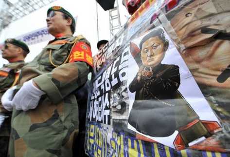 Unos veteranos surcoreanos exhiben una caricatura del líder norcoreano, Kim Jong-un. (Foto Prensa Libre: AFP)