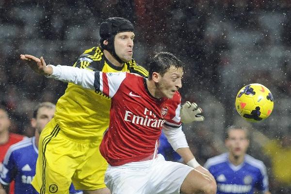 El jugador del Arsenal Mesut Özil (c) disputa un balón con el arquero del Chelsea, Petr Cech (i). (Foto Prensa Libre: EFE)