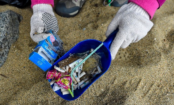 Voluntarios chilenos muestran los objetos que recogieron la playa de Valparaíso. (Foto Prensa Libre: AFP).