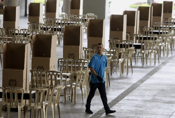 Un colombiano prepara puestos de votación para el plebiscito. (Foto Prensa Libre: EFE).