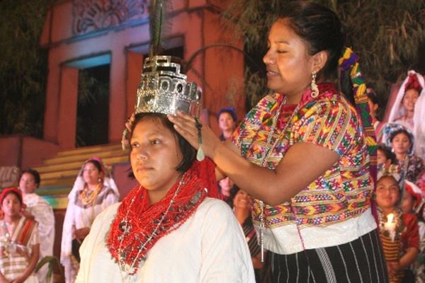 Lidia Dominga Canto, soberana saliente, coloca la corona a Lesly Yesenia Tupil, nueva Rabín Ajaw. (Foto Prensa Libre: Ángel Martín Tax).