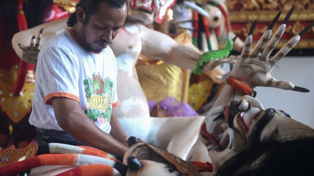 Un hombre prepara las estatuas conocidas como Ogoh-ogoh, que simbolizan el mal. AFP