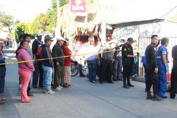 Curiosos observan el cadáver de José Lino Chalcú, quien fue encontrado en Panajachel. (Foto Prensa Libre: Ángel Julajuj)