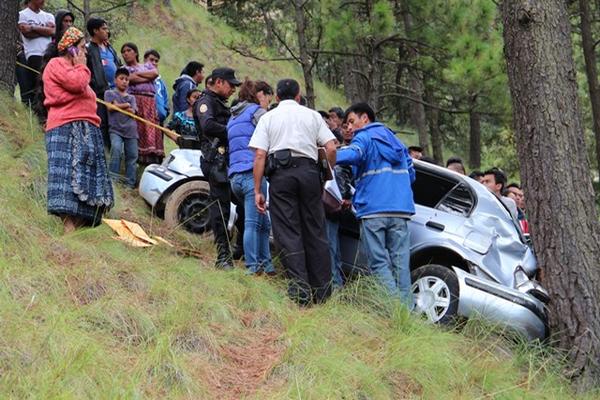 Curiosos observan el taxi en el que murió el conductor, el cual se embarrancó y se detuvo en un árbol. (Foto Prensa Libre: Édgar Domínguez)<br _mce_bogus="1"/>
