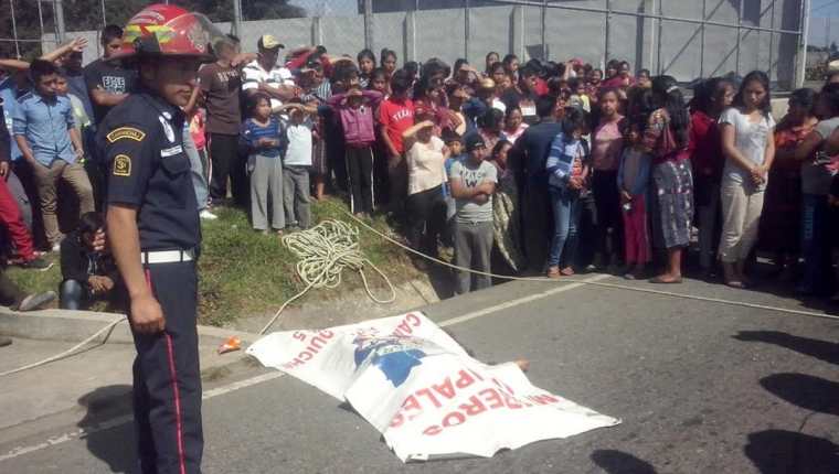 Socorristas resguardan el cadáver de un ayudante de autobús, quien murió en Chichicastenango. (Foto Prensa Libre: Óscar Figueroa)