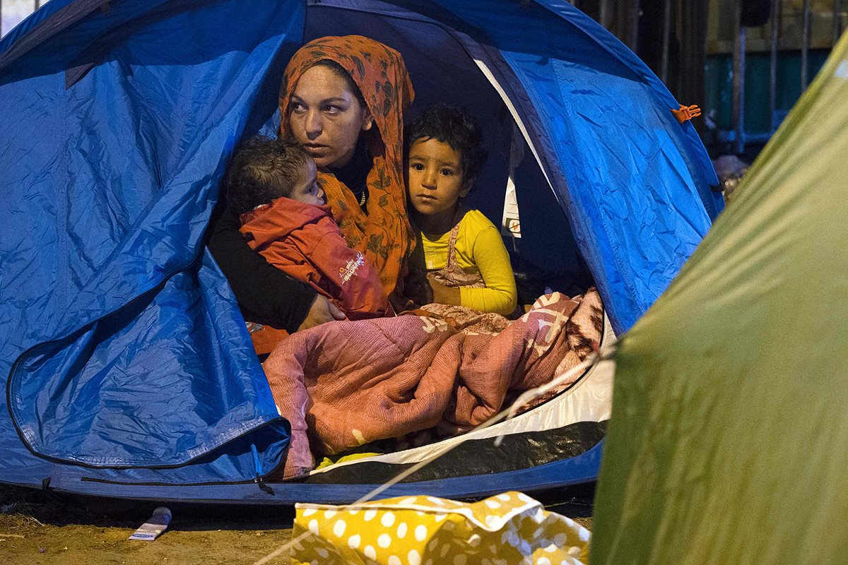 Una familia de migrantes sirios descansa en un campamento improvisado en Calais, Francia, de donde provienen la mayoría de migrantes que llegan a Gran Bretaña. (Foto Prensa Libre: AFP).