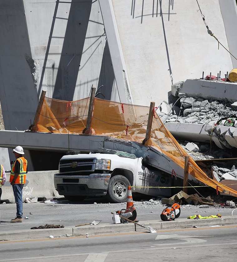 Trabajadores investigan la escena donde un puente peatonal se derrumbó en Miami. (AFP).