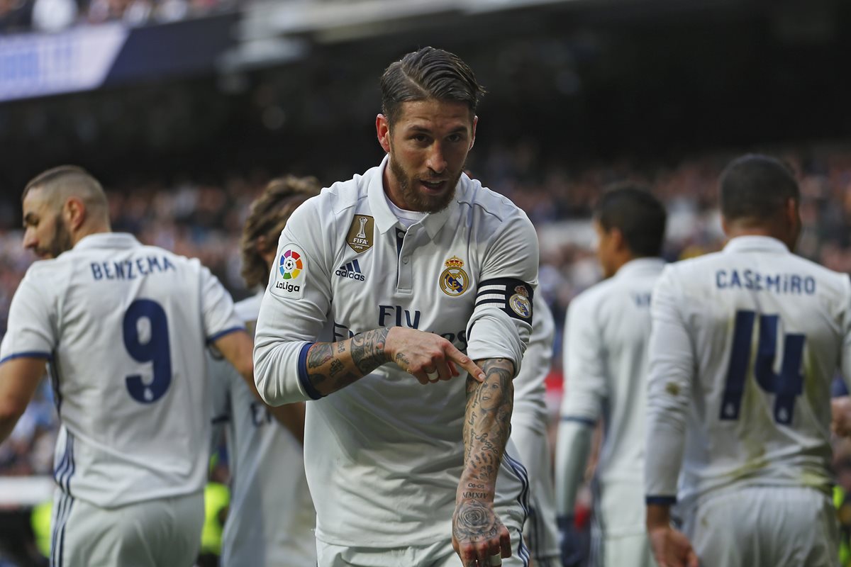 El defensa español Sergio Ramos del Real Madrid señala el tatuaje del rostro de su mamá en el festejo de uno de sus goles contra el Málaga. (Foto Prensa Libre: AP)