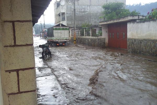 Un motorista se detiene para revisar su motocicleta debido a las inundaciones. (Foto Prensa Libre: Guerner Lorenzo)