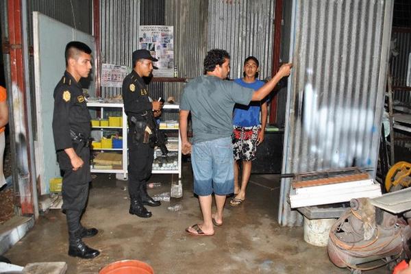 Agentes de la Policía conversan con los propietarios del taller que fue asaltado. (Foto Prensa Libre: Rigoberto Escobar)<br _mce_bogus="1"/>