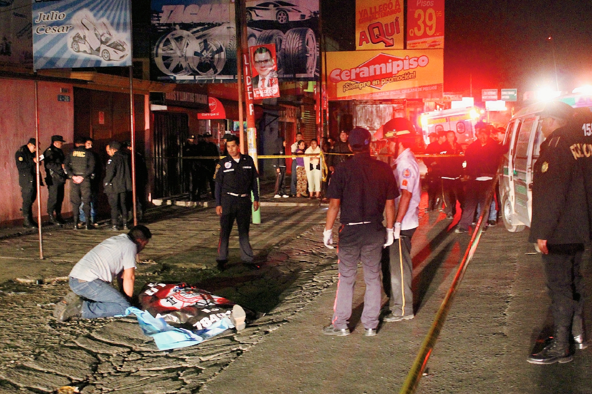 Gerson Bladimir Salazar Villeda, observa el cuerpo de su hermano Juan José, quien fue muerto de un balazo en el abdomen, en el km 53 de la ruta Interamericana, en Chimaltenango. (Foto Prensa Libre: Víctor Chamalé)