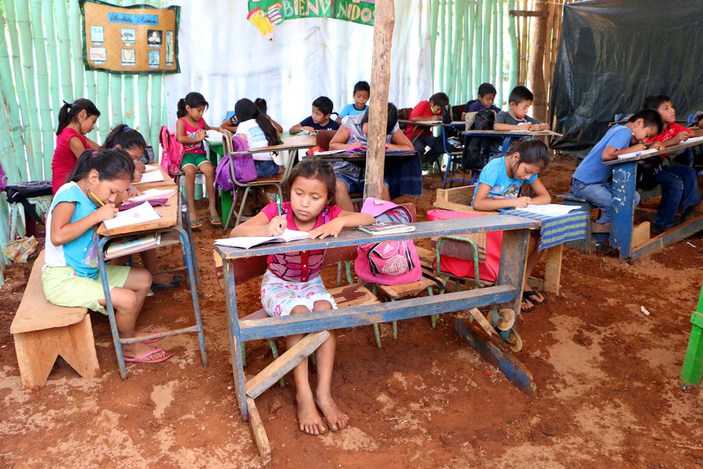 Niños de El Asintal estudian en galeras de lámina y bambú