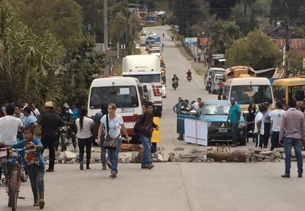 Un grupo de vecinos bloquea el paso en el kilómetro 199 de la ruta entre Santa Cruz Verapaz y San Cristóbal Verapaz. (Foto Prensa Libre: Eduardo Sam)