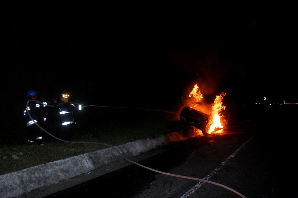 Socorristas controlar fuego en vehículo, en Pastores, Sacatepéquez. (Foto Prensa Libre: Víctor Chamalé)
