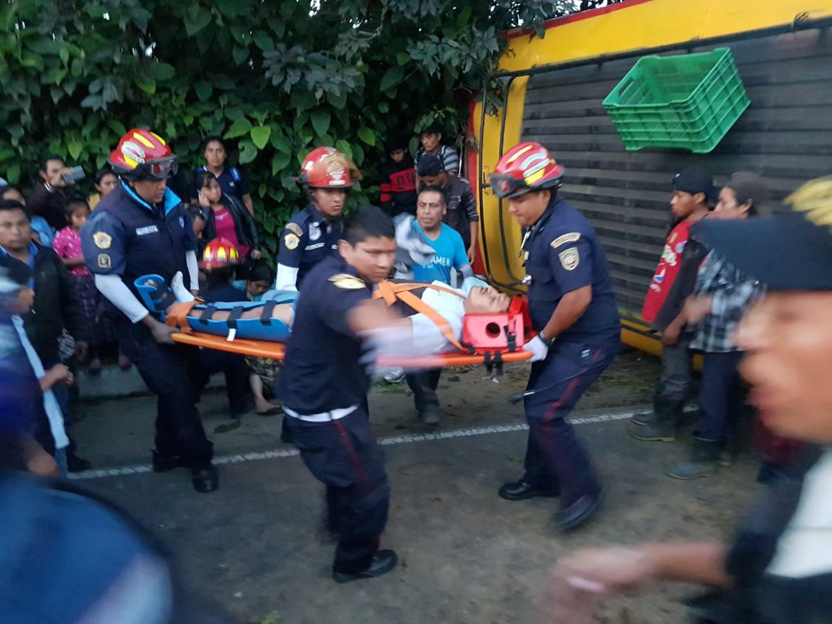 Bomberos Municipales Departamentales trasladan a uno de los heridos en el accidente del bus, en Santa María Cauque, Santiago Sacatepéquez. (Foto Prensa Libre: CBMD)