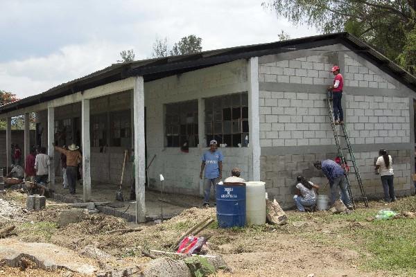 Hombres y mujeres       participan en el remozamiento  de Escuela Tipo Federación de Salamá, Baja Verapaz.