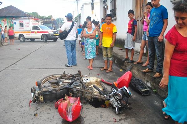 Socorristas y vecinos observan estado de la motocicleta, en la zona 1 de la cabecera de Retalhuleu. (Foto Prensa Libre: Jorge Tizol)<br _mce_bogus="1"/>