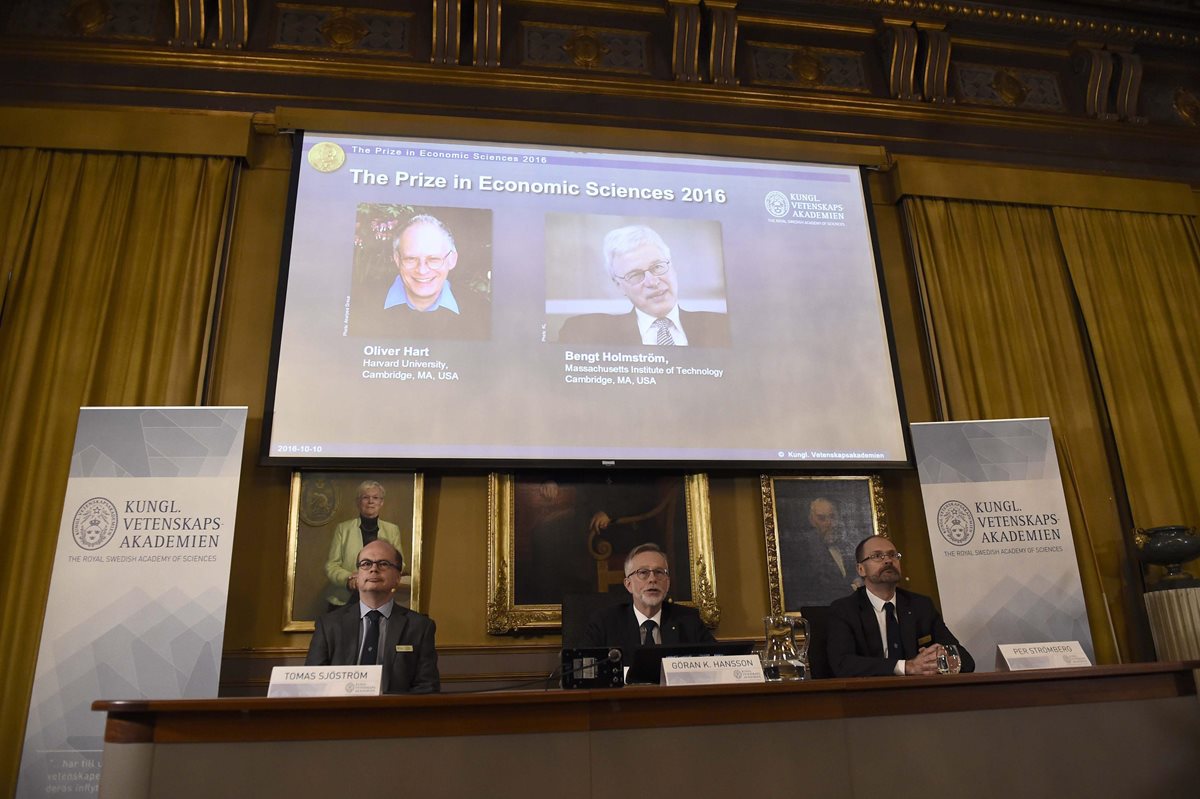 El Comité para el Nobel de Economía con una imagen de los premiados (Foto Prensa Libre: EFE)