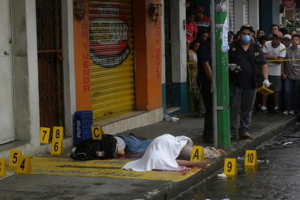 Fiscales del Ministerio Público levantan evidencias en el lugar donde fueron acribillados dos hombres en Mazatenango. (Foto Prensa Libre: Omar Méndez)