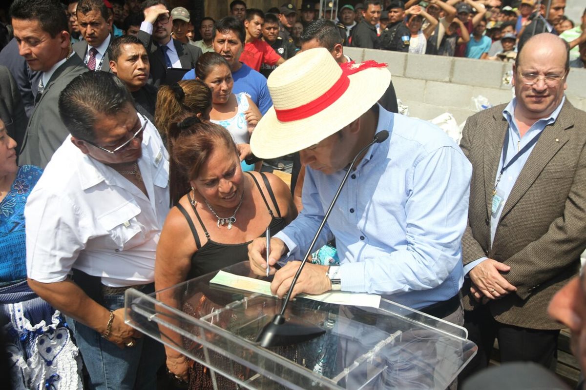 El presidente Jimmy Morales firma el cheque por Q20 mil para la reconstrucción de La Terminal. (Foto Prensa Libre: Erick Ávila)