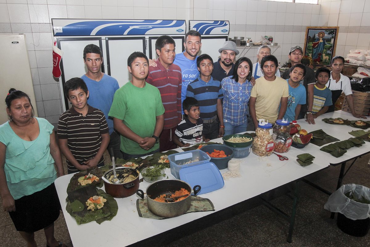 David Guerra, Ana Lucía Martínez y Pedro Luis Peña junto a los niños del Hogar Rafael Ayau en la cocina donde prepararon los tamales. (Foto Prensa Libre: Norvin Mendoza)