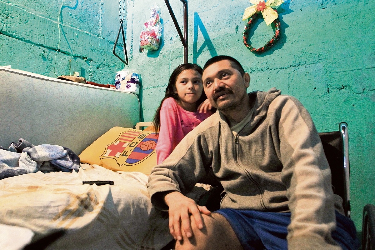 Miguel Ángel Díaz Felipe, de 38 años, relata sus dificultades acompañado de una de sus hijas. (Foto Prensa Libre: Edwin Bercián)