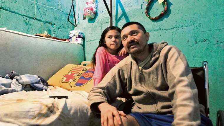 Miguel Ángel Díaz Felipe, de 38 años, relata sus dificultades acompañado de una de sus hijas. (Foto Prensa Libre: Edwin Bercián)