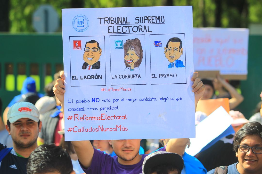 Manifestante levanta una pancarta en alusión a varios partido políticos. (Prensa Libre Foto: Álvaro Interiano)