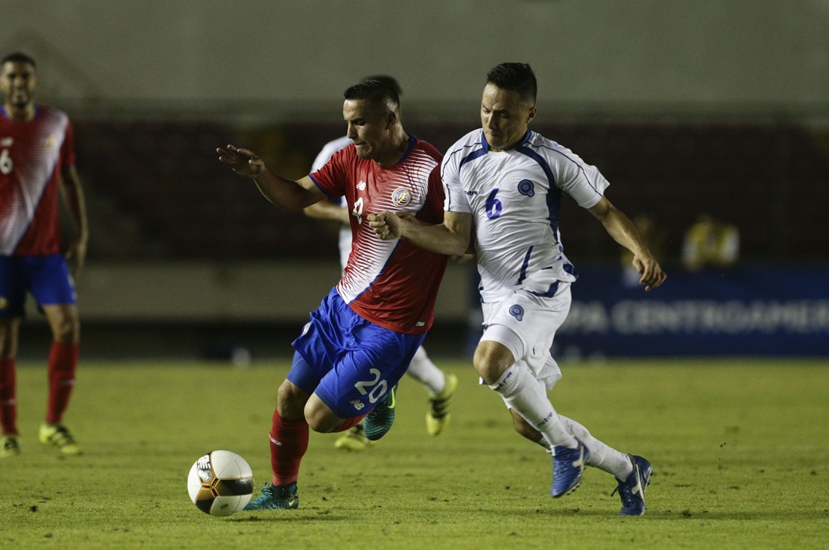 El costarricense Allan Miranda pelea por el balón con Richard Menjivar de El Salvador. (Foto Prensa Libre: AFP)