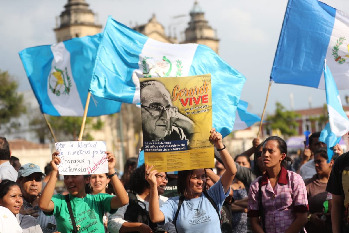 Entre las banderas de Guatemala sobresale un afiche que recuerda el asesinato de Juan Gerardi