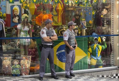 La Policía brasileña resguarda una tienda llena de regalía del Mundial, en Sao Paulo. (Foto Prensa Libre/AP)