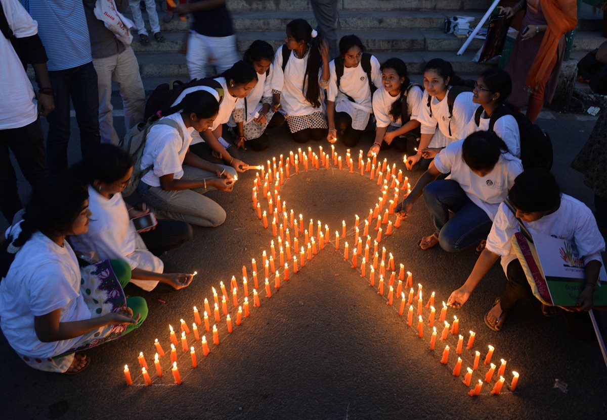 Estudiantes de la India encienden velas en memoria de las víctimas del cáncer en el mundo.(Foto Prensa Libre: AFP).
