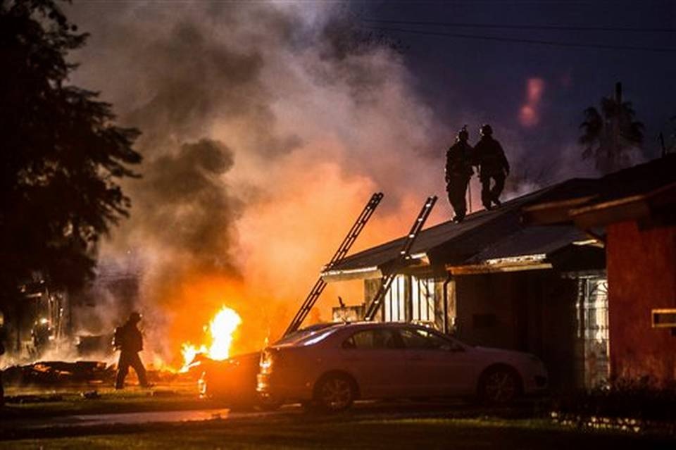 Una columna de humo y fuego marca el lugar en el que un pequeño avión se estrelló sobre dos viviendas en Riverside, en el sur de California. (Foto Prensa Libre: AFP)