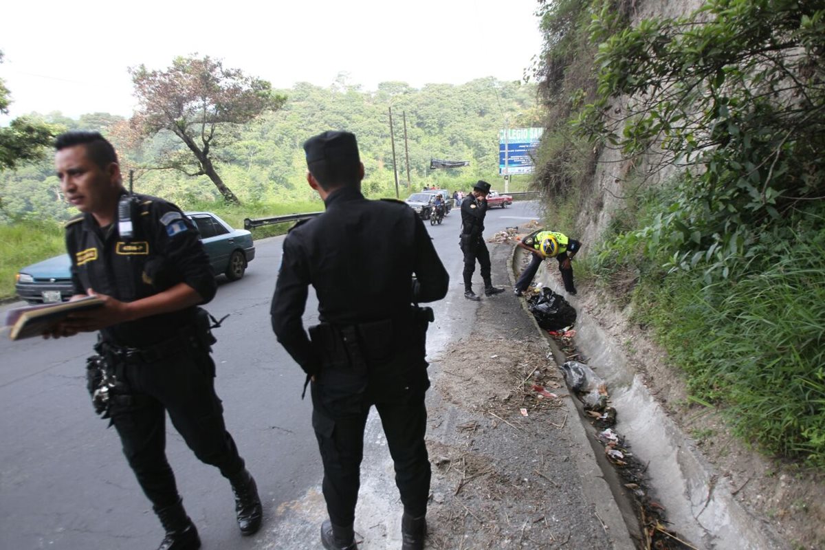 La PNC resguarda el área cercana en espera que el MP llegue y retire los restos humanos, dejados en la ruta en una bolsa plástica. (Foto Prensa Libre: Érick Avila)
