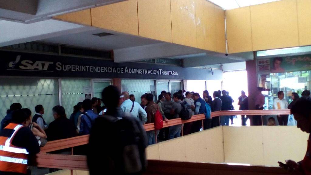 Por desacuerdo en la centralización del servicio para trámites de terceras personas decenas de personas manifiestan y bloquean la agencia de la SAT en Monserrat. (Foto, Prensa Libre: cortesía Blanca Lily)
