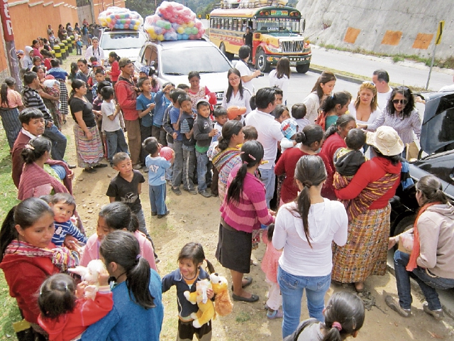 Personas llegan a sitios de la carretera Interamericana a entregar juguetes a los niños. (Foto Prensa Libre: Ángel Julajuj).
