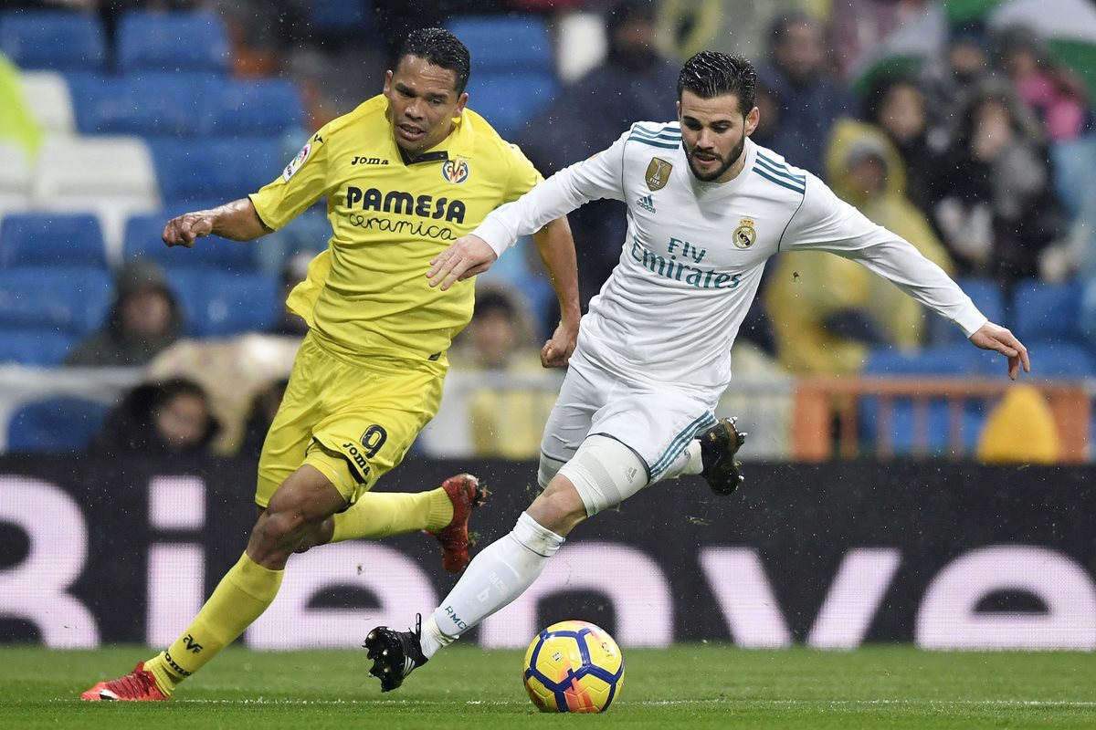 Nacho Fernández disputa el balón con Carlos Bacca durante el encuentro entre el Real Madrid y el Villarreal. (Foto Prensa Libre: AFP)