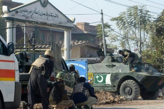Fuerzas de seguridad paquistaníes toman posiciones en el exterior de la escuel blanco de un ataque talibán. (Foto Prensa Libre: AFP)
