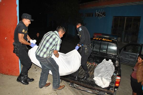 Agentes de la Policía Nacional Civil trasladan los cadáveres de los esposos. (Foto Prensa Libre: Rigoberto Escobar).
