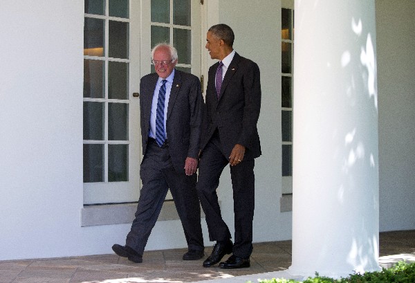 Barack Obama camina junto a Bernie Sanders en la Casa Blanca en Washington DC. (AP).