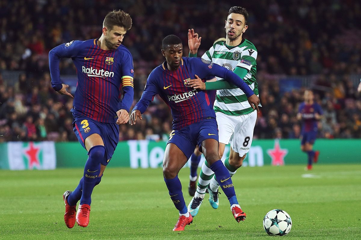 Los defensas del FC Barcelona, Gerard Piqué y Nelson Semedo, disputan el balón con Bruno Fernandes.