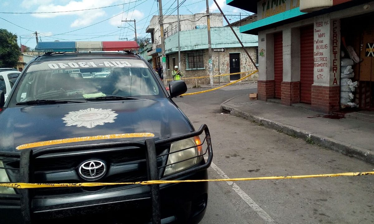 La PNC establece un perímetro para proteger evidencia alrededor de la ferretería donde dos hombres fueron baleados. (Foto Prensa Libre: Erick Ávila)