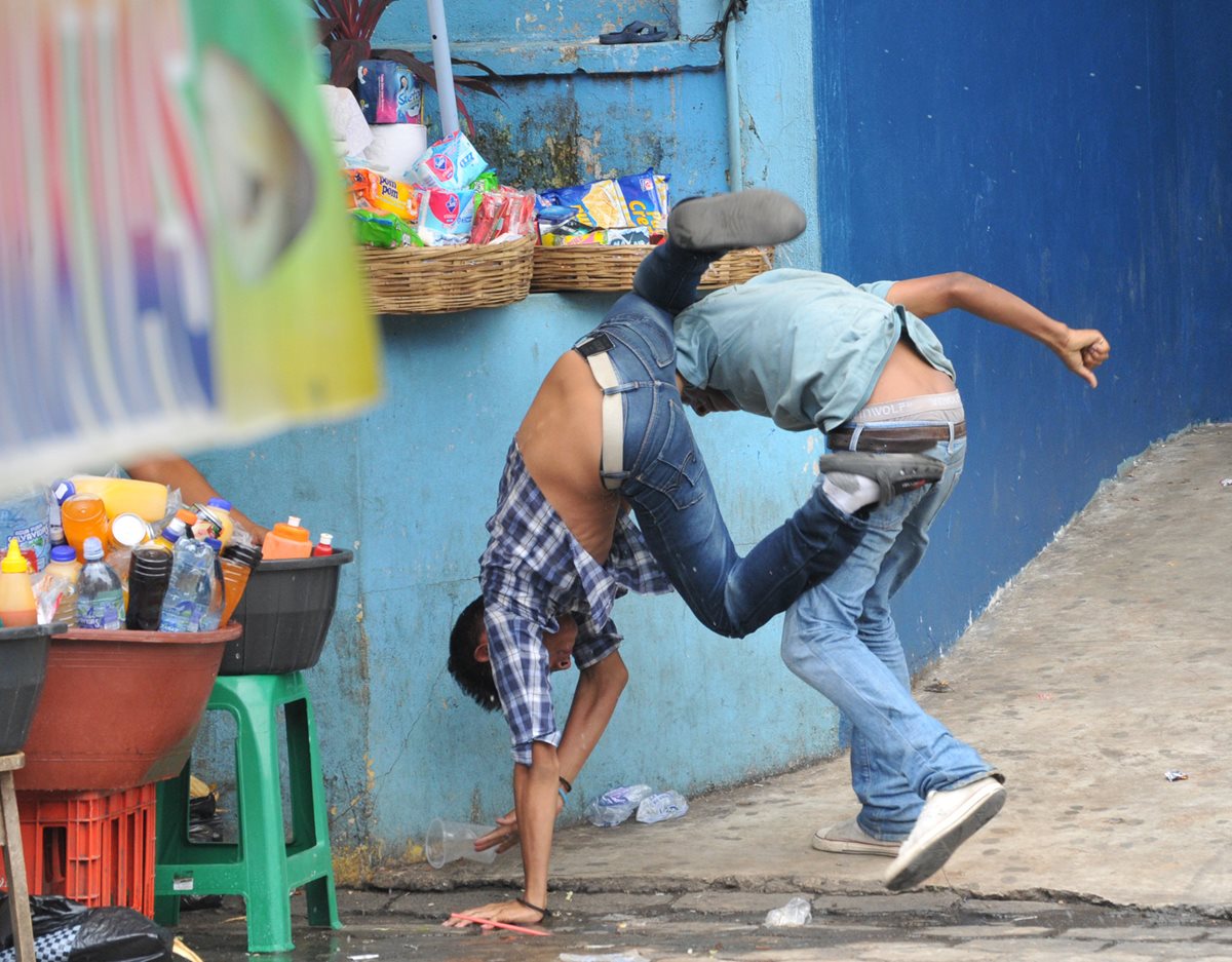 Dos ayudantes de microbuses pelean luego de discusión para atraer pasajeros en Coatepeque. (Foto Prensa Libre: Alexánder Coyoy)
