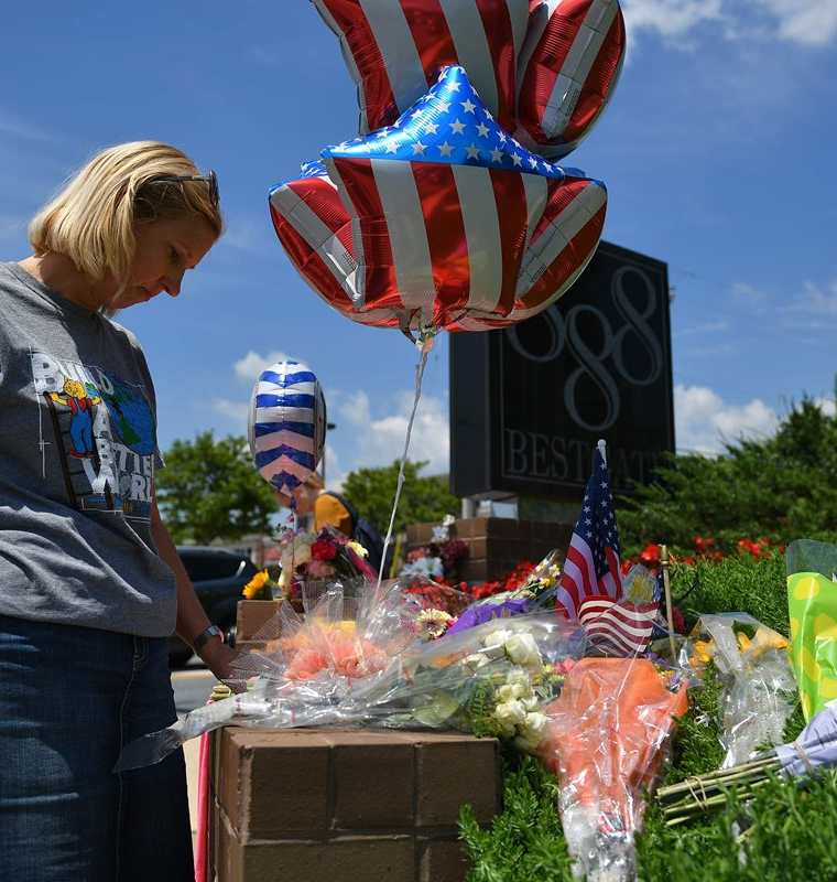 Personas colocan arreglos florales en honor de los periodistas muertos en Annapolis. (Foto Prensa Libre: AFP)