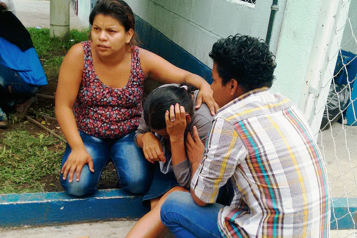 Glenda Cortez, cuyo hijo murió en el Hospital Regional de Cuilapa, es consolada por sus dos hijos mayores. (Foto Prensa Libre: Oswaldo Cardona)