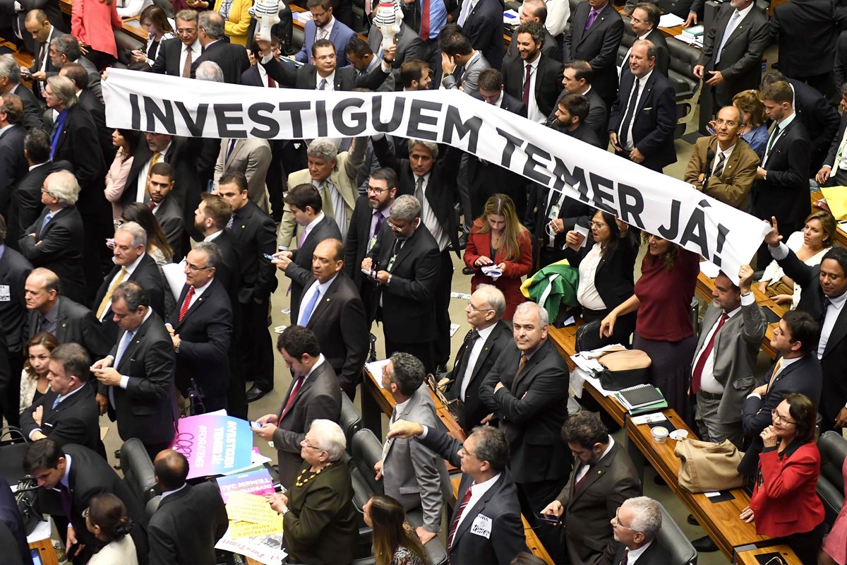 Los legisladores de la oposición tienen una pancarta que dice "¡Investiga a Temer ahora!".(Foto Prensa Libre:AFP).