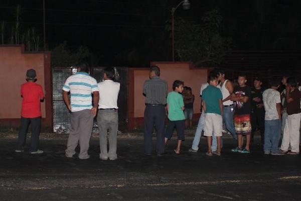 Curiosos observan la escena del crimen en el barrio Aurora. (Foto Prensa Libre: Alex Coyoy)<br _mce_bogus="1"/>