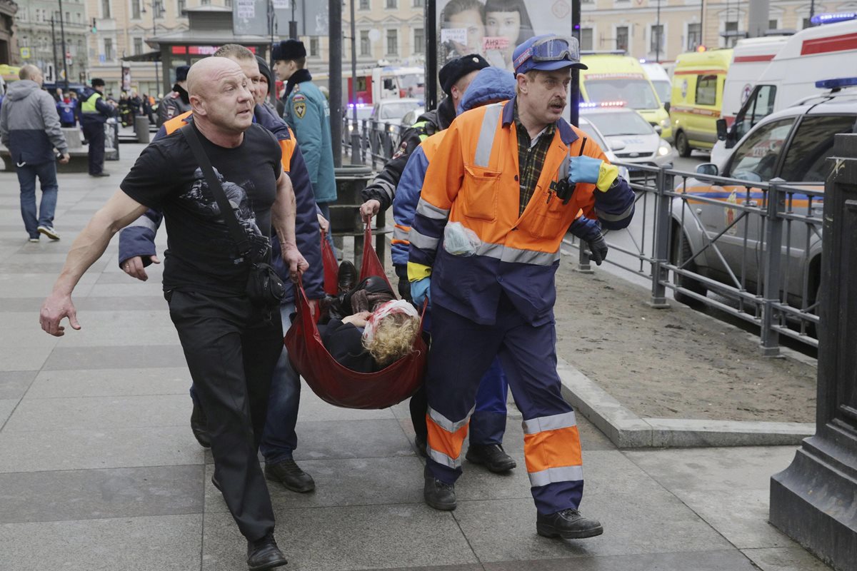 Bomberos y trabajadores de los servicios de emergencias transportan a una mujer, víctima del atentado terrorista ocurrido en el metro de San Petersburgo. (Foto Prensa Libre: EFE).