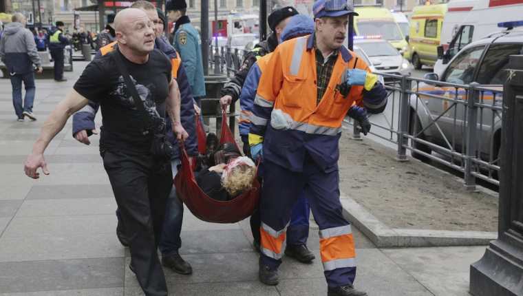 Bomberos y trabajadores de los servicios de emergencias transportan a una mujer, víctima del atentado terrorista ocurrido en el metro de San Petersburgo. (Foto Prensa Libre: EFE).